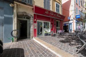 een rood gebouw met tafels en stoelen in een straat bij Coeur de Provence - Appt climatisé in Draguignan