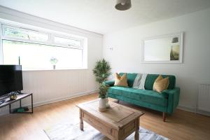 - un salon avec un canapé vert et une table dans l'établissement Queensferry Apartment, à North Queensferry