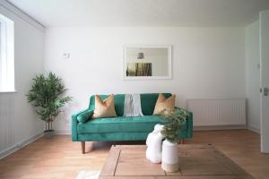sala de estar con sofá verde y alfombra en Queensferry Apartment en North Queensferry