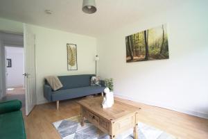 - un salon avec un canapé bleu et une table basse dans l'établissement Queensferry Apartment, à North Queensferry