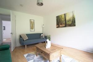 a living room with a blue couch and a coffee table at Queensferry Apartment in North Queensferry