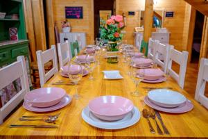 a wooden table with plates and wine glasses on it at Madera y Miel Casa Rural con niños en Puy du Fou in Guadamur