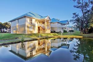 una casa con su reflejo en el agua en Caribbean Estates Holiday Resort, en Port Edward
