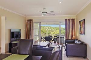 a living room with a couch and a television at Caribbean Estates Holiday Resort in Port Edward