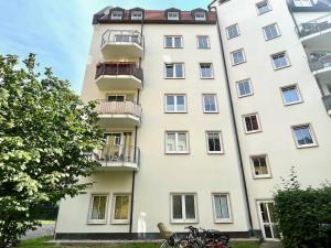 ein hohes weißes Gebäude mit Fahrrädern davor in der Unterkunft Apartment Uptown im Herzen der Dresdner Neustadt! in Dresden