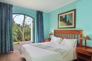 a bedroom with a bed and a large window at Caribbean Estates Holiday Resort in Port Edward