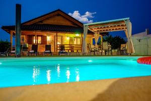 a house with a swimming pool at night at Madera y Miel Casa Rural con niños en Puy du Fou in Guadamur