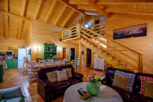 una sala de estar con una escalera en una cabaña de madera en Madera y Miel Casa Rural con niños en Puy du Fou, en Guadamur