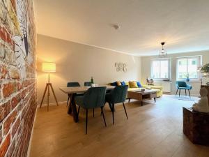ein Wohnzimmer mit einem Tisch, Stühlen und einem Sofa in der Unterkunft Apartment Uptown im Herzen der Dresdner Neustadt! in Dresden