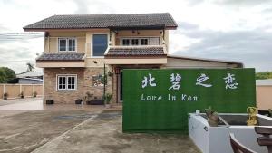 a house with a sign that says love in koru at Love In Kan in Wang Khanai
