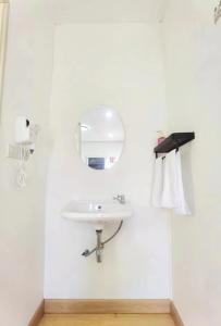 a white bathroom with a sink and a mirror at Love In Kan in Wang Khanai