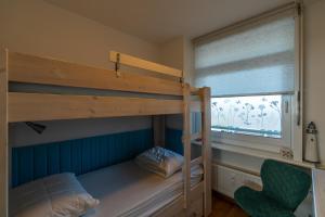 een slaapkamer met 2 stapelbedden en een raam bij Appartement Majelle in Egmond aan Zee