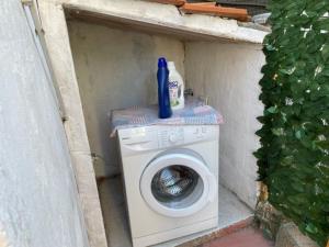 een wasmachine met een blauwe fles erop bij Stefania Guest House in Giba
