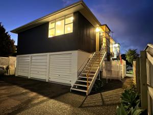 a house with a staircase leading up to a garage at Plymouth Central City 2 Bedroom Apartments in New Plymouth