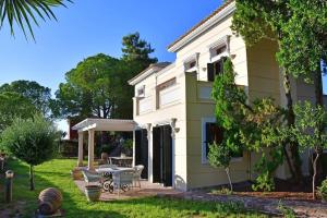 a house with a patio and a table in the yard at Villa Althea in Perdika