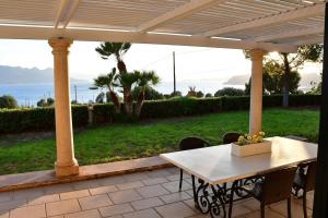 a white table and chairs on a patio at Villa Althea in Perdhika