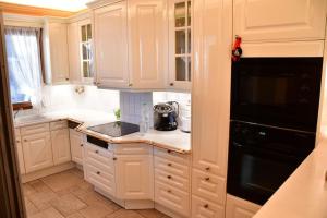 a kitchen with white cabinets and a black appliance at Villa Althea in Perdhika +28 photos