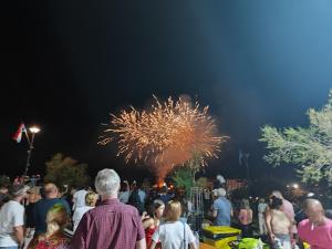 una multitud de personas de pie en frente de un espectáculo de fuegos artificiales en VILLA APARTMENTS FILIP, en Starigrad-Paklenica