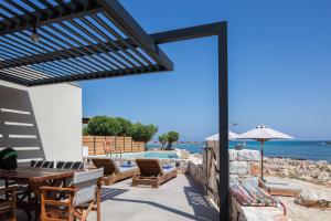 Un patio con mesa y sillas y vista al mar. en Villa Amina, en La Canea 38 fotos más