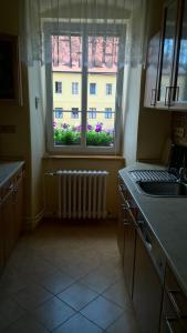 a kitchen with a window and a sink and a radiator at Apartmany Žatec in Žatec