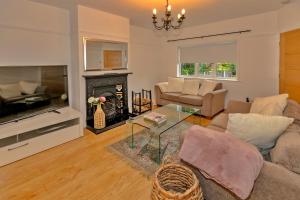 ein Wohnzimmer mit einem Sofa und einem Kamin in der Unterkunft Finest Retreats - DeBarnes House in Solihull