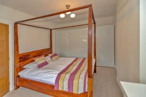 ein Bett mit einem Holzrahmen in einem Schlafzimmer in der Unterkunft Finest Retreats - DeBarnes House in Solihull