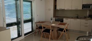 a kitchen with a wooden table and chairs in it at Sunset Apartment in Sevid