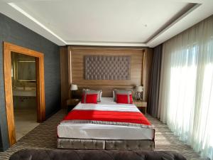 1 dormitorio con 1 cama grande con almohadas rojas en Ramada by Wyndham Nigde, en Nigde
