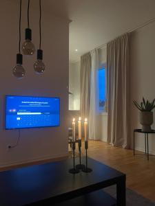 uma sala de estar com duas velas e uma televisão de ecrã plano em Gröna Huset em Torsby