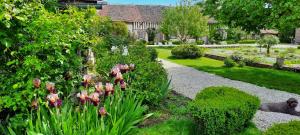 a garden with flowers and plants and a house at Domaine de la Creuse in Moussey