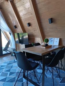 uma sala de jantar com uma mesa de madeira e cadeiras em Stone Chalets LUNA em Jajce