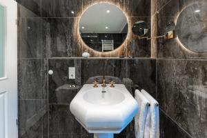een badkamer met een witte wastafel en een spiegel bij Juwel am Meer - Smaragd in Bad Zwischenahn