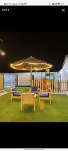 a group of benches sitting under an umbrella at القصر الريفي in Al Khafji