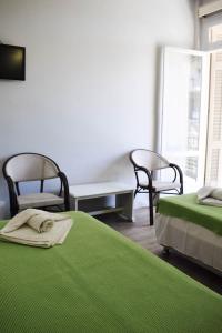 a bedroom with two beds and a table and chairs at City Center Hotel in Kalamata +22 photos