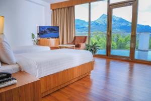 ein Schlafzimmer mit einem großen Bett und einem großen Fenster in der Unterkunft Hotel Sky Sierra Wayanad in Kalpatta