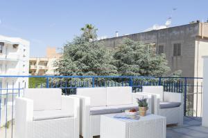 eine Gruppe weißer Stühle und Tische auf einem Balkon in der Unterkunft Costa Azzurra Gallipoli in Gallipoli