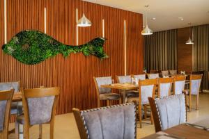 a dining room with tables and chairs and a wall at Hotel Sky Sierra Wayanad in Kalpetta