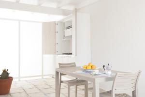 a white dining room with a table and chairs at Costa Azzurra Gallipoli in Gallipoli