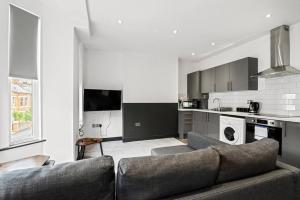 a living room with a couch and a kitchen at Sleek and Stylish Converted 1Bed in Old Boiler Factory - Flat 4 in Nottingham