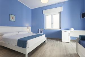 una camera blu con un letto e una finestra di Costa Azzurra Gallipoli a Gallipoli