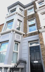 a house with a black door and a brick building at Stylish Margate apartment in Margate