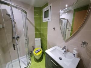 a bathroom with a sink and a shower and a toilet at GreenHill Holiday Suites in Sarti