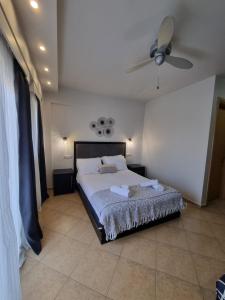 a bedroom with a bed and a ceiling fan at GreenHill Holiday Suites in Sarti