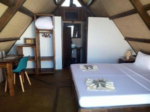 Schlafzimmer mit einem Bett, einem Schreibtisch und einer Leiter in der Unterkunft HOTEL H1 MANANJARY 