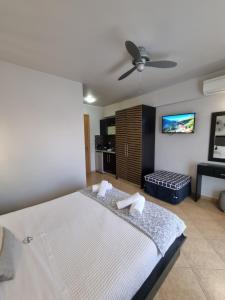 a bedroom with a bed and a flat screen tv at GreenHill Holiday Suites in Sarti