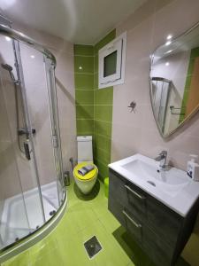 a bathroom with a sink and a shower and a toilet at GreenHill Holiday Suites in Sarti