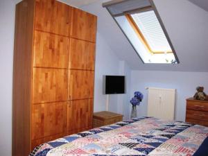 Un dormitorio con un gran armario de madera y una cama en Villa-Sonja, en Zingst
