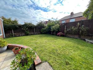 einen Hinterhof mit einem Garten mit einem Zaun und einem Hof sidx sidx in der Unterkunft Seaview House, Tynemouth - Luxury Family Holiday Home in Tynemouth