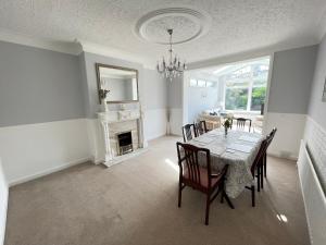 ein Esszimmer mit einem Tisch, Stühlen und einem Kamin in der Unterkunft Seaview House, Tynemouth - Luxury Family Holiday Home in Tynemouth
