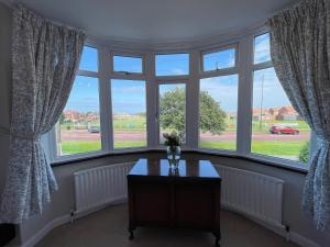 a room with a table in front of windows at Seaview House, Tynemouth - Luxury Family Holiday Home in Tynemouth +28 photos